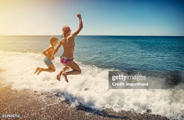 kinderen springen in zee - bibbona stockfoto's en -beelden