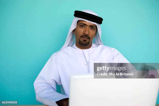 an emirati businessman on his laptop. - dish dash stock pictures, royalty-free photos & images