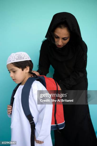 a mother fixes her sons school bag. - parental guidance stock pictures, royalty-free photos & images