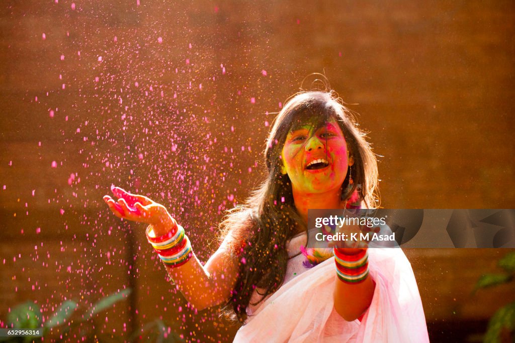 A girl with color powder attend celebrate the Holi Festival...