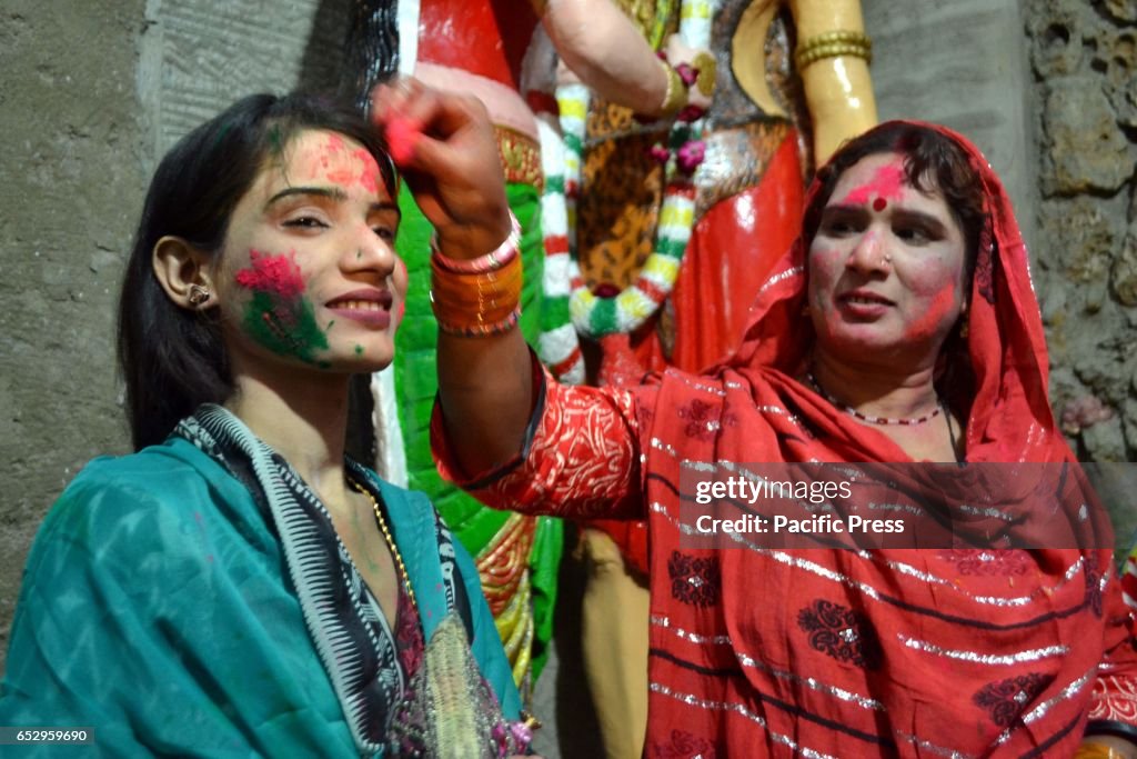 Hindu women are celebrating Holi while putting colors on...