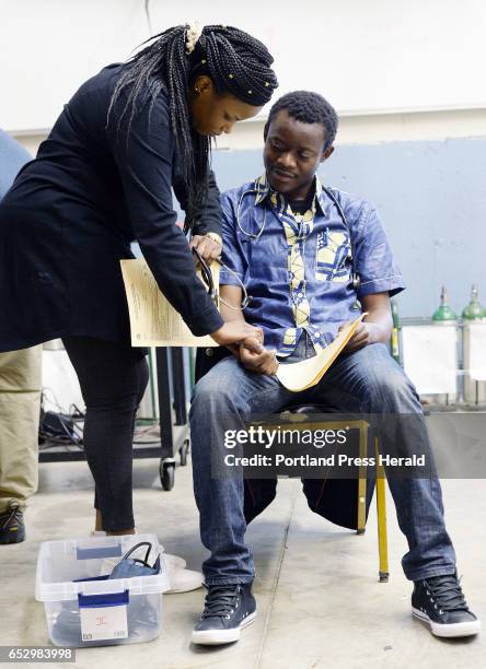 Jolly Ntirumenyerwa of Portland, originally from the Democratic Republic of Congo does a medical assesment on Axels Samuntu of Portland, who is also...