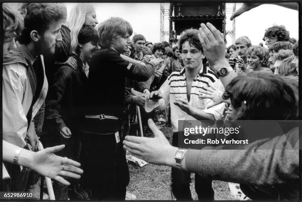 Bono of U2 walks amongst the front rows of the crowd while performing during the 'October' tour at Torhout festival, Belgium, 3rd July 1982.