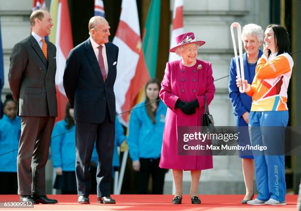 Prince Edward, Earl of Wessex, Prince Philip, Duke of Edinburgh and Queen Elizabeth II look on as former track cyclist Anna Meares of Australia holds...