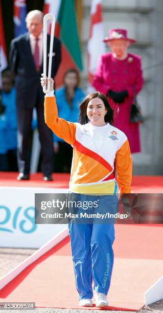 Prince Philip, Duke of Edinburgh and Queen Elizabeth II look on as former track cyclist Anna Meares of Australia holds The Queen's Baton during the...