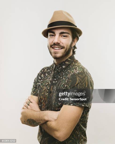 stylish young man standing with his arms crossed - man hat stock pictures, royalty-free photos & images