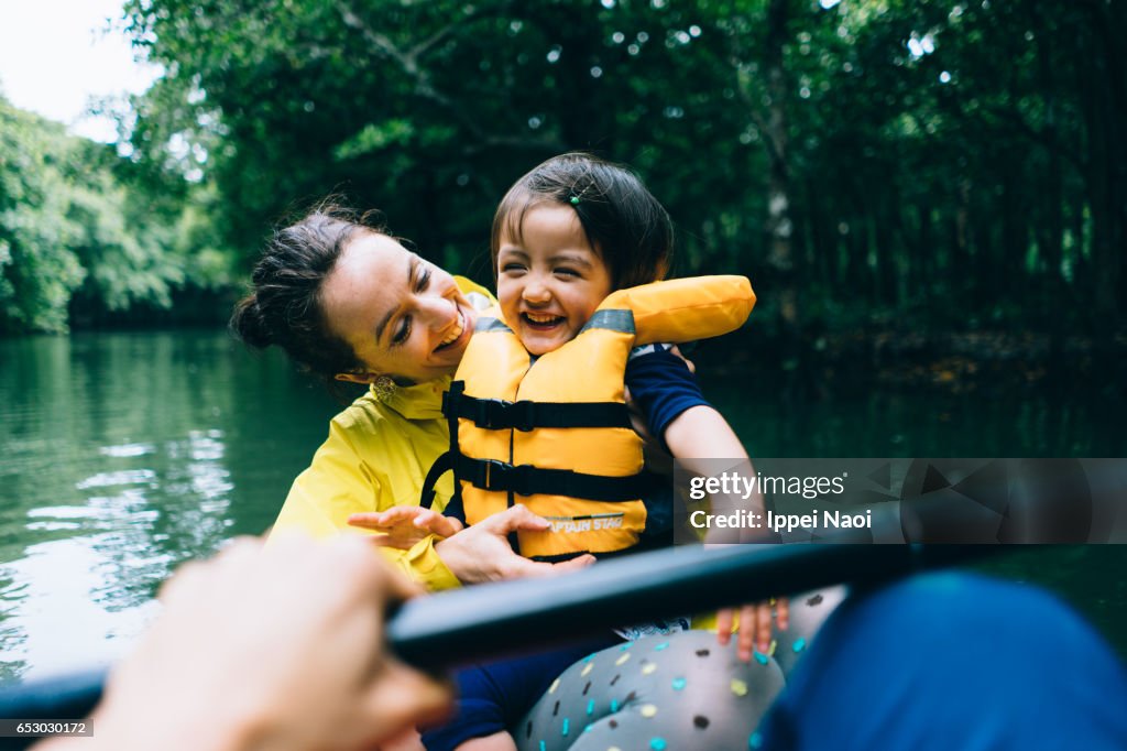 Mother and child having fun with mangrove river kayaking