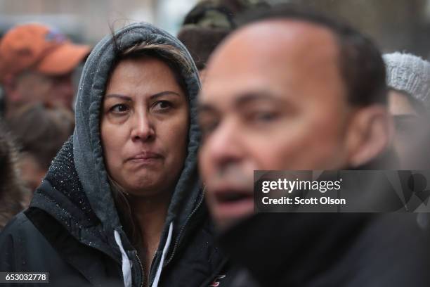 Francisca Lino listens as Rep. Luis Gutierrez speaks to the press after leaving the office of Immigration Services where he was briefly handcuffed...