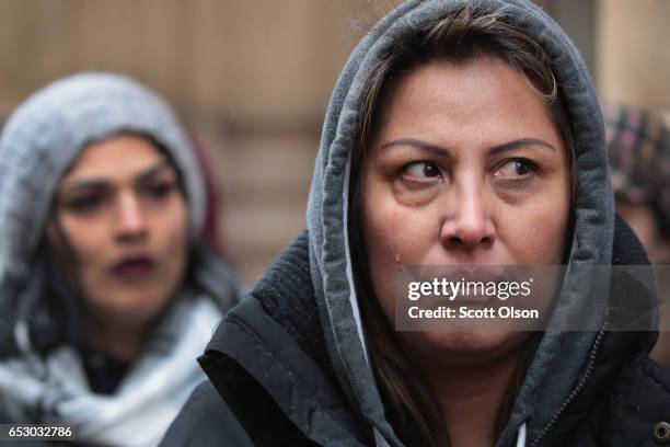 Francisca Lino listens as Rep. Luis Gutierrez speaks to the press after leaving the office of Immigration Services where he was briefly handcuffed...