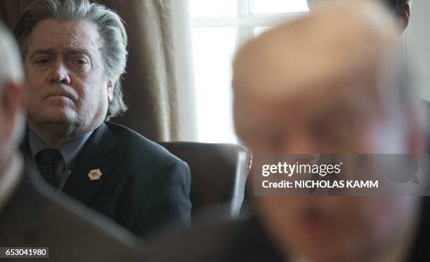 Senior White House adviser Steve Bannon listens as US President Donald Trump speaks to the press before he meets with his Cabinet in the Cabinet Room...