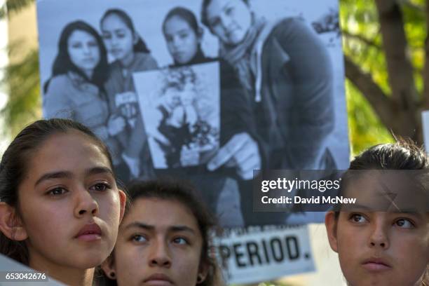 Daughters of Romulo Avelica-Gonzalez, Fatima , Yunleni and Diana , stand near a family photo as loved ones and supporters rally for his release...