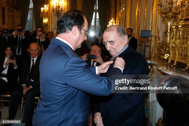 French President, Francois Hollande elevates Claude Brasseur to the rank of "Officier de la Legion d'Honneur" at Elysee Palace on March 13, 2017 in...