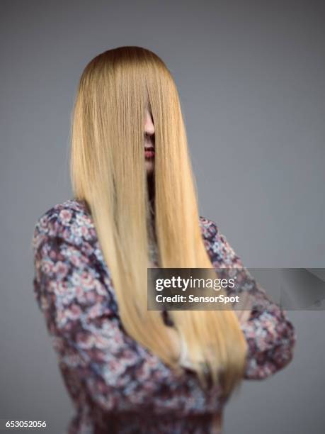 young woman with face covered by long blonde hair - long straight hair stock pictures, royalty-free photos & images