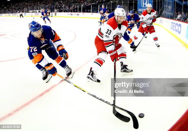 Anthony Beauvillier of the New York Islanders and Derek Ryan of the Carolina Hurricanes battle for the puck during their game at the Barclays Center...