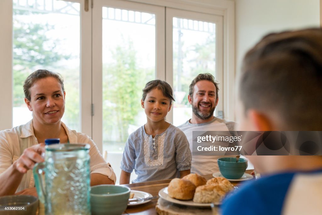 Junge Familie mit angenehmen Gespräch beim Frühstück im Speisesaal