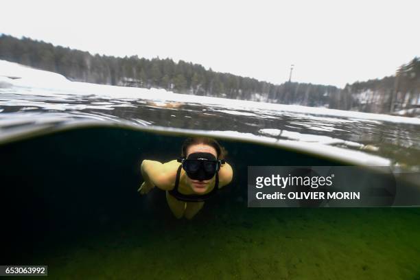 Johanna Nordblad Finnish freediver swims under Ice layer in a bathing suit during an Ice-freediving training session on February 28 in a green lake...