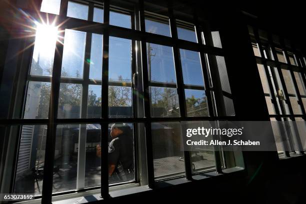 Charente LaGarde, senior detention officer, is viewed in the recreation yard through movie prop jail cell bars installed for a movie company that...