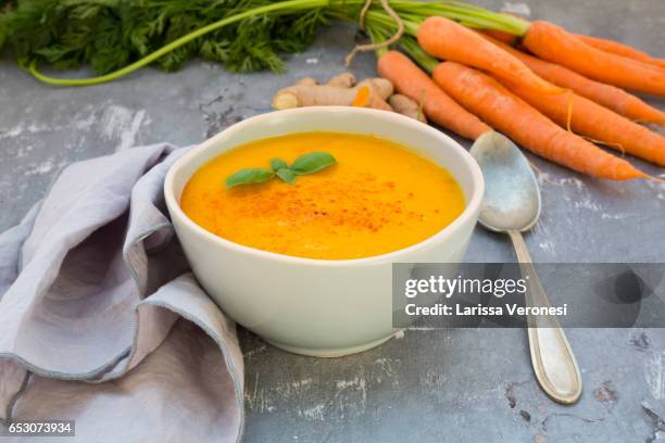 bowl of carrot turmeric soup with ginger, chili and basil - soup bowl stock pictures, royalty-free photos & images