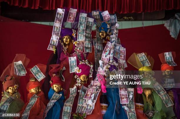 In this photo taken on March 7 currency notes adorn offerings inside a shrine in Shwe Ku Ni village during the Ko Gyi Kyaw Nat festival. The medium...