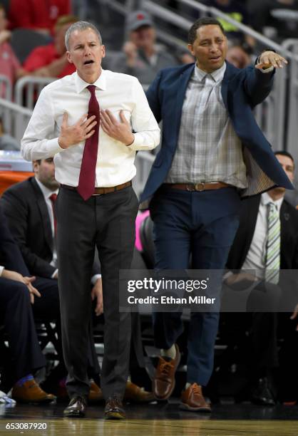 Head coach Andy Enfield and associate head coach Tony Bland of the USC Trojans react during a quarterfinal game of the Pac-12 Basketball Tournament...