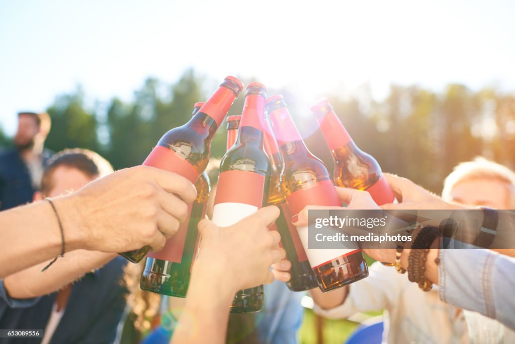 Raising beer bottles to toast