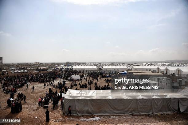 Displaced residents of the Iraqi city of Mosul gather at the Hamam al- Alil camp for internally displaced people on March 13, 2017. Fleeing the...