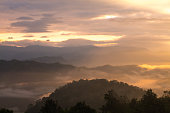 Sun shining through the clouds with silhouetted mountians at Mae Moei National Park,Tak province,Thailand,defocused