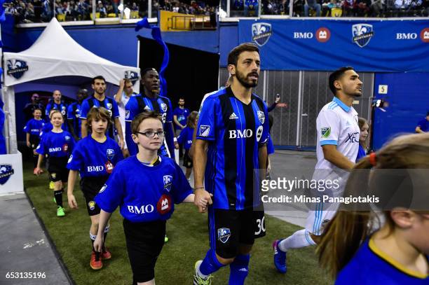 March 11: Hernan Bernardello of the Montreal Impact is escorted to the field by a child during the MLS game against the Seattle Sounders FC at...