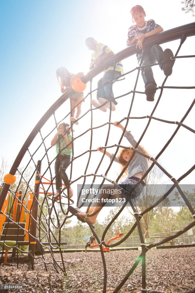 Multi-ethnischen Grundschulkinder spielen am Spielplatz im Park.