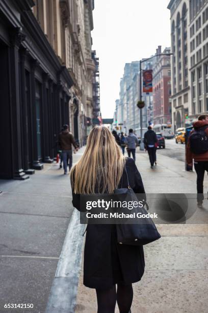 a young woman dressed nicely walks down a manhattan sidewalk - busy sidewalk stock pictures, royalty-free photos & images