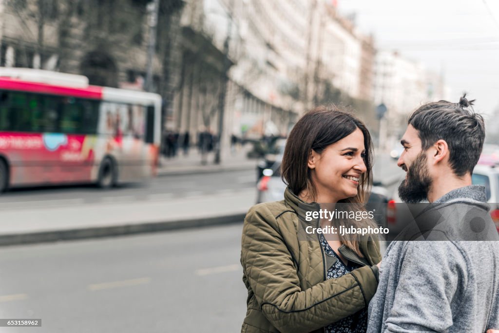 Lyckliga unga paret tittar på varandra på gatan