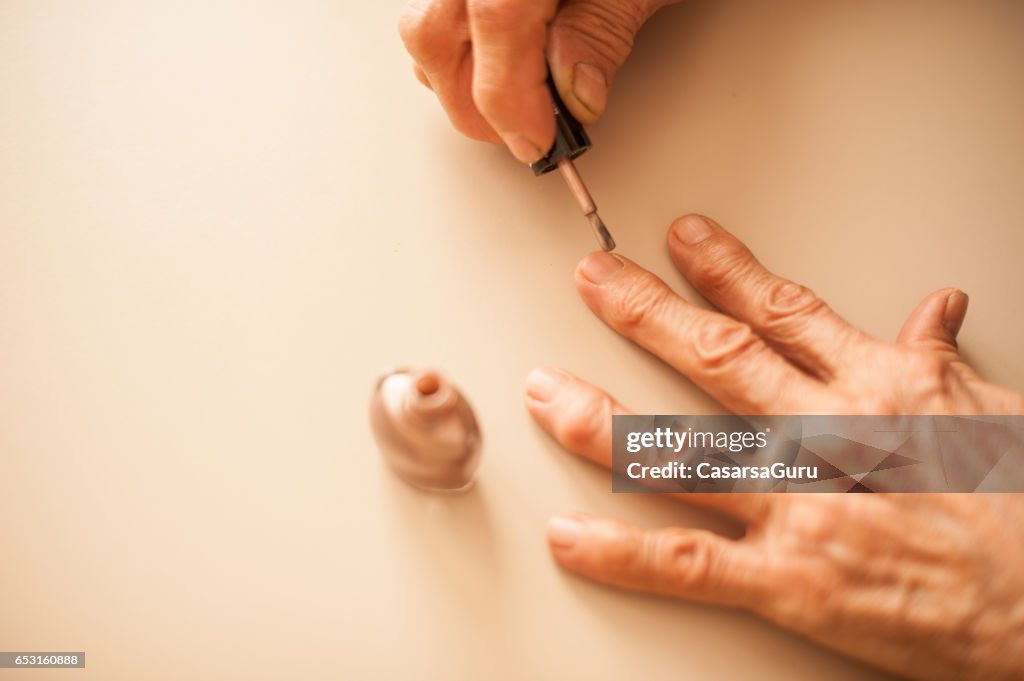 Senior Woman Applying Fingernails - Close Up Hands