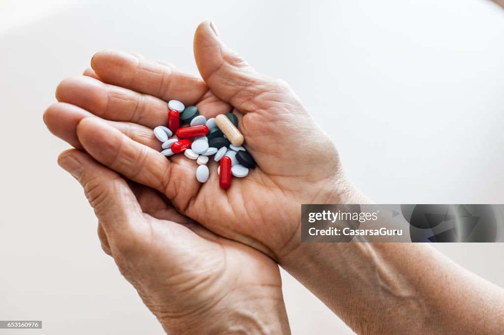 Old Hands Taking Medicine - Close Up