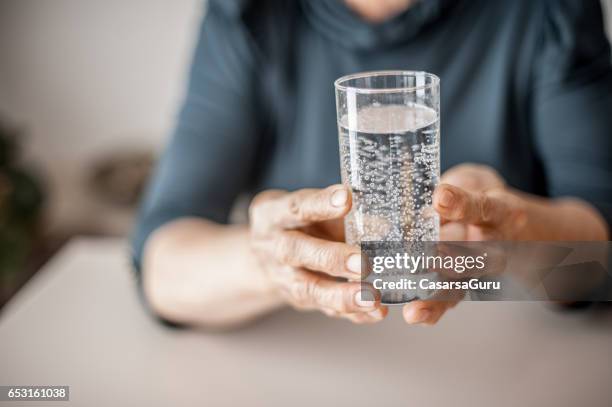 tableta efervescente que se toma por mujer senior - cierre - comprimido efervescente fotografías e imágenes de stock