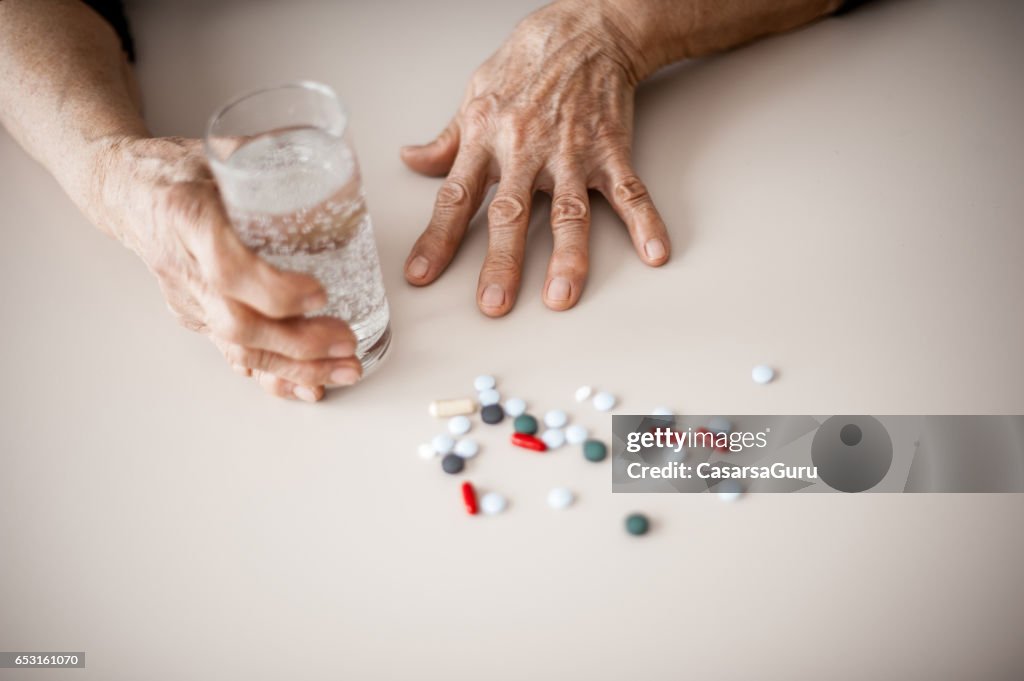 Senior Woman Wrinkled Hands Choosing Medicine To Take