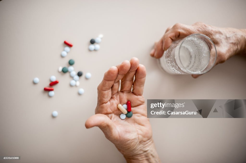 Senior Woman Wrinkled Hands Choosing Medicine To Take