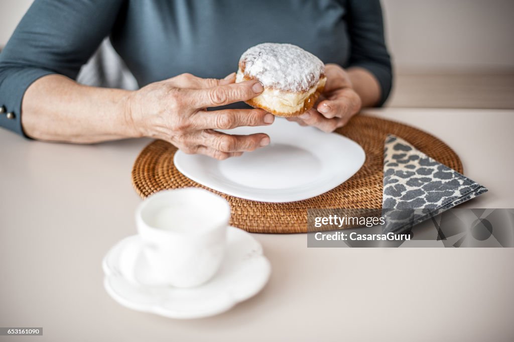 Senior vrouw de regels overtreden door het eten van Donut