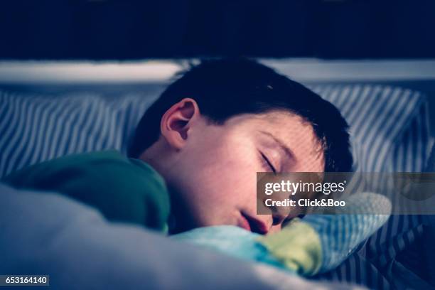 boy sleeping in his bed. - sleeping boys stockfoto's en -beelden