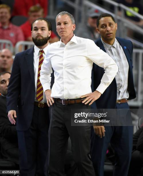 Director of operations for men's basketball Michael Swets, head coach Andy Enfield and associate head coach Tony Bland of the USC Trojans look on...