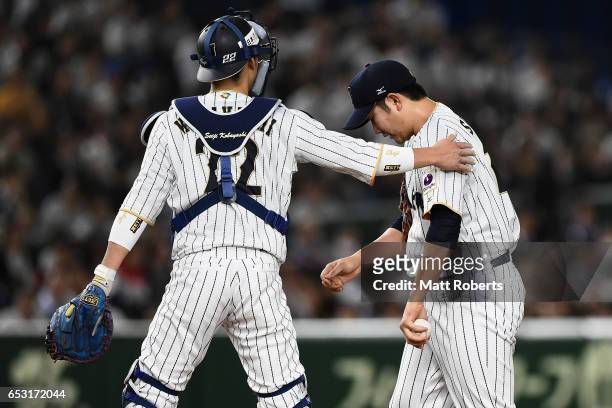 Catcher Seiji Kobayashi of Japan talks to Pitcher Tomoyuki Sugano after Catcher Yosvani Alarcon of Cuba hitting a double in the top of the second...