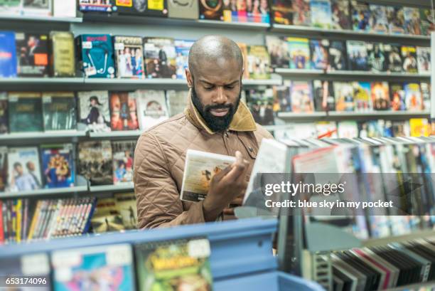 a man shopping for dvd films. - dvd fotografías e imágenes de stock