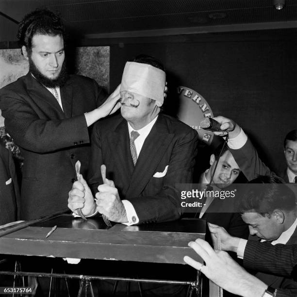 Spanish artist Salvador Dali is about to create blindfolded a portrait of one of Jules Verne's heroes with forks in Paris on May 7, 1966.