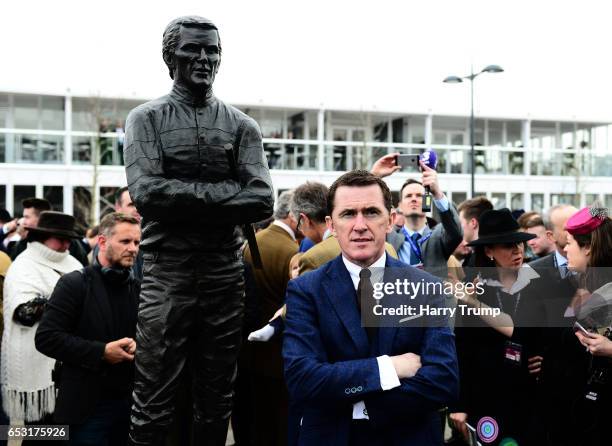 Sir A.P. McCoy poses alongside a statue of himself which was unveiled during Champion Day of the Cheltenham Festival at Cheltenham Racecourse on...