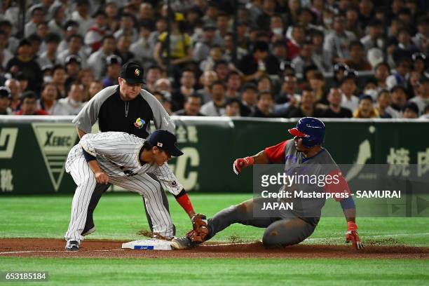 Catcher Yosvani Alarcon of Cuba is tagged out by Infielder Hayato Sakamoto of Japan on the third base in the top of the fourth inning during the...