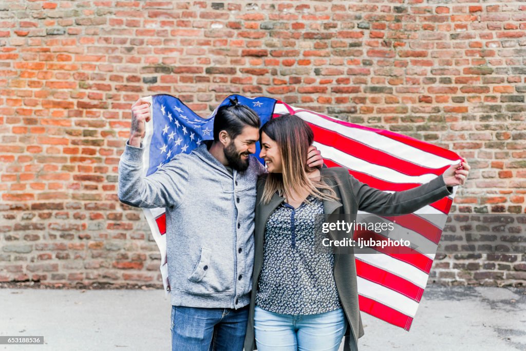 Fashionable hip couple in front of American flag New York