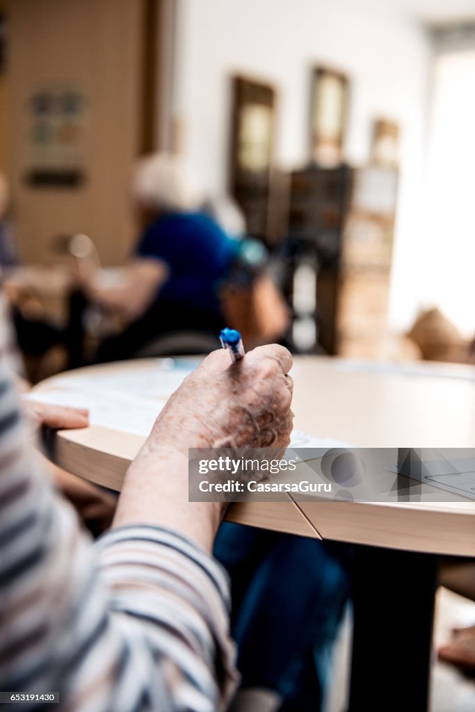 Senior en el hogar del jubilado para resolver crucigramas