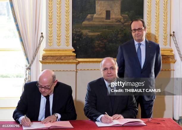 French Interior Minister Bruno Le Roux and French Secretary of State for Development and Francophonie Jean-Marie Le Guen sign while France's...