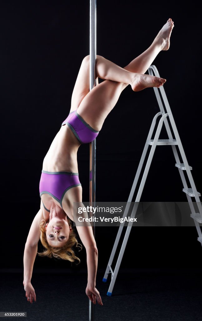 Das starke und anmutige junge Mädchen Durchführung akrobatische Übungen am pylon