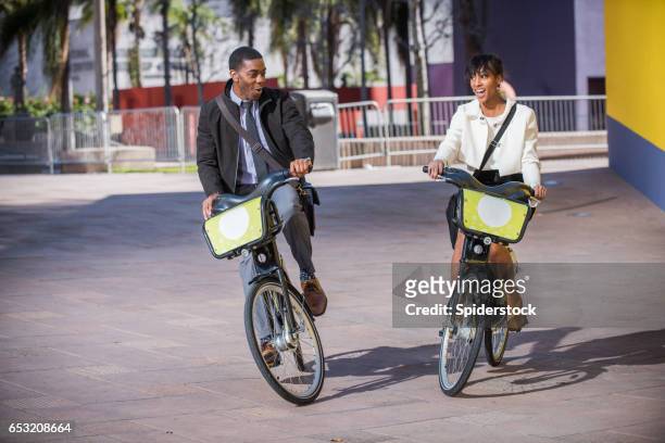 twee african american millennial zakenpartners met openbare fietsen in downtown los angeles - partnership men bikes stockfoto's en -beelden