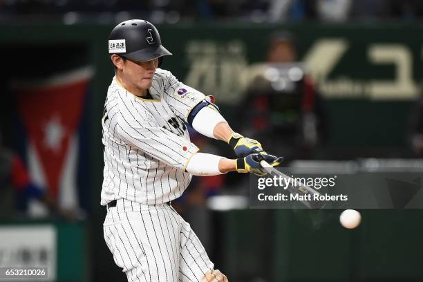 Catcher Seiji Kobayashi of Japan hits a RBI single to make it 5-5 in the bottom of the sixth inning during the World Baseball Classic Pool E Game...